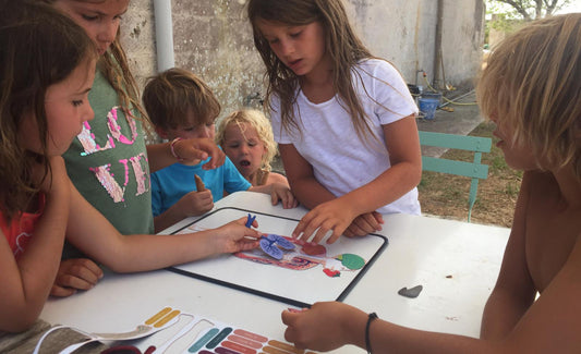 Enfants jouant avec le jeu magnétique Anatomie sur une table de jardin en métal — Ma Cabane à Rêves
