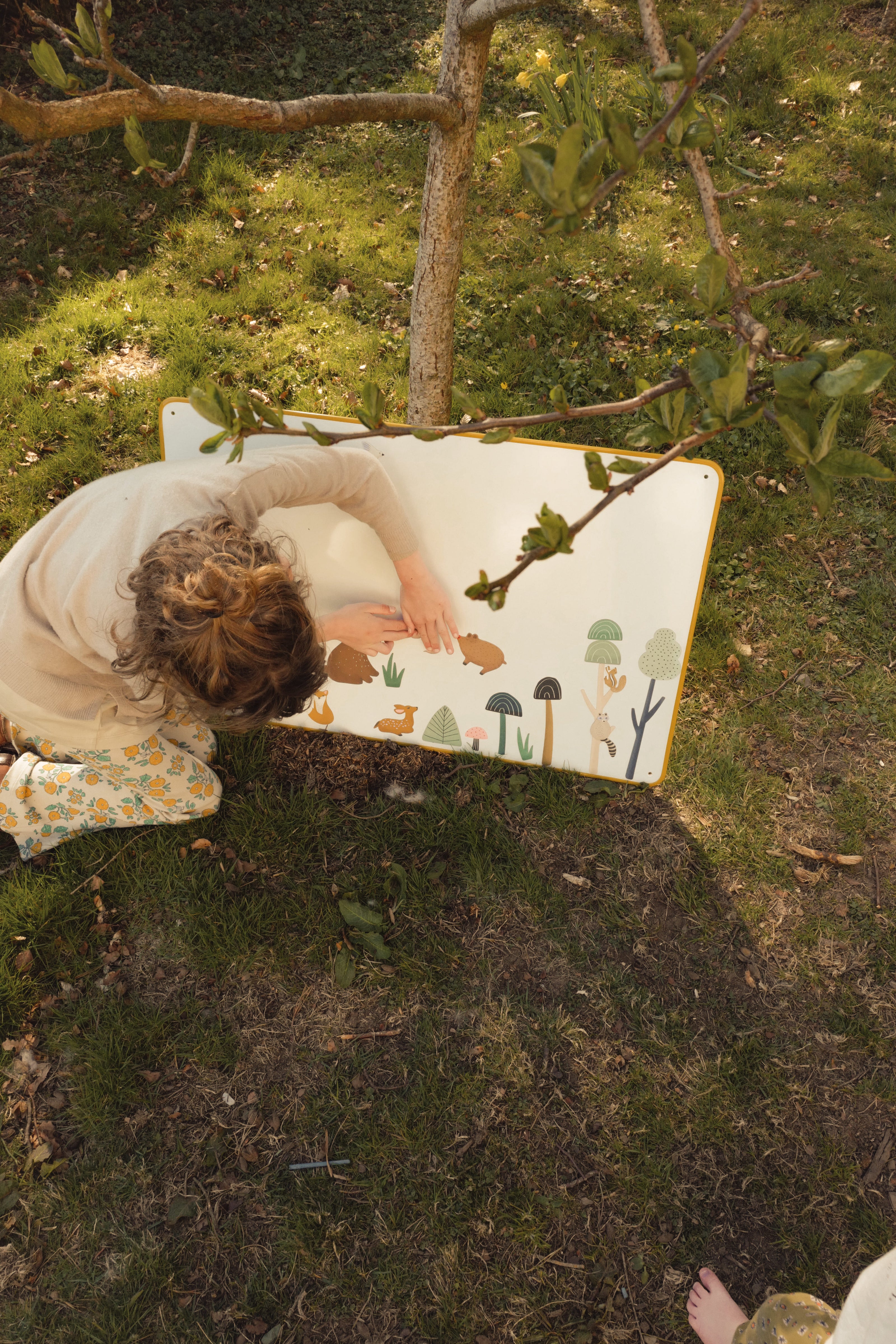 Enfant jouant avec des magnets animaux de la forêt sur un grand tableau blanc magnétique bois 80x55cm Ma Cabane à Rêves, posé au sol
